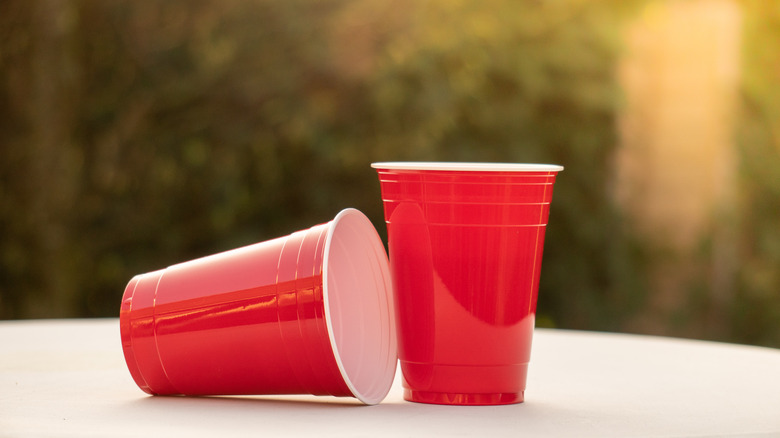 two empty red Solo cups on an outdoor table