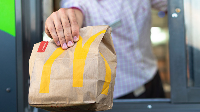 Hand holding McDonald's takeout bag