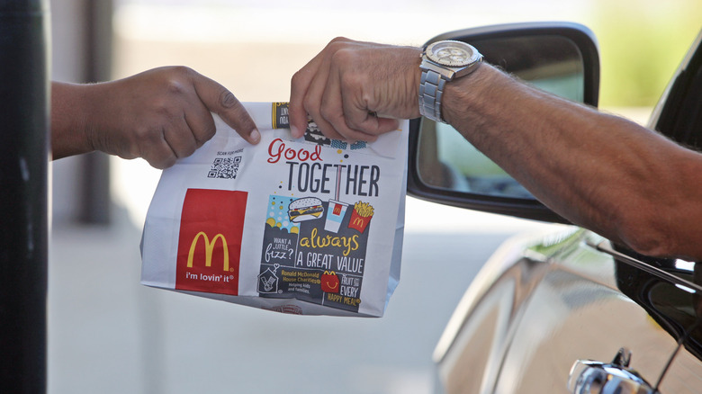 McDonald's employee handing food bag