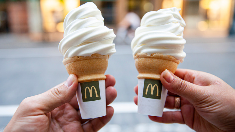 two hands holding McDonalds ice cream cones