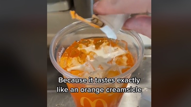 Creamer being put in cup of Fanta