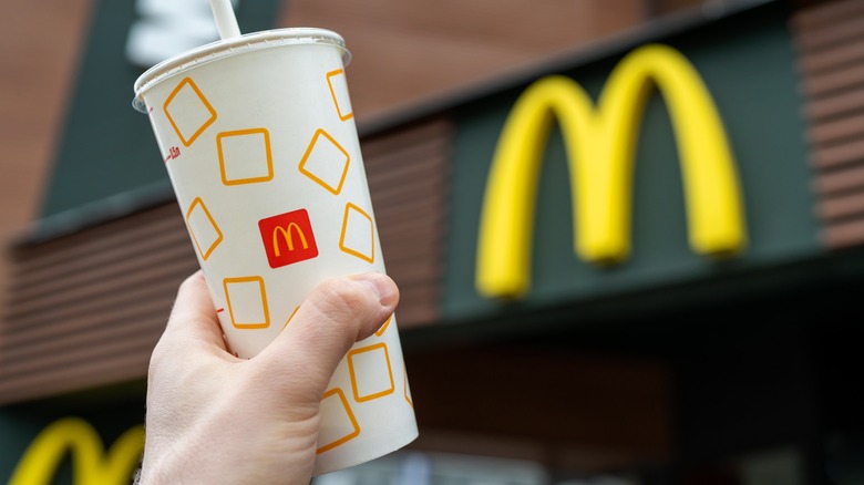 holding McDonald's cup outside restaurant