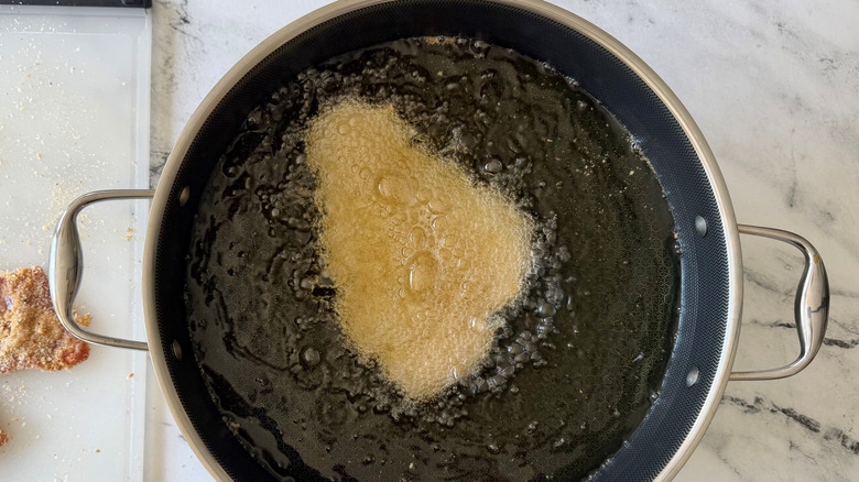 Breaded pork cutlet frying in oil
