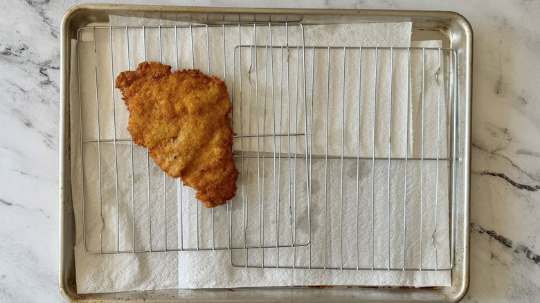 Fried pork cutlet draining on wire rack