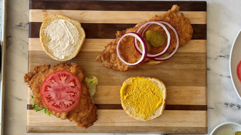 Open faced Hoosier pork tenderloin sandwiches with various toppings and spreads