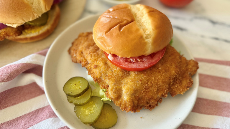 Hoosier pork tenderloin sandwich on plate with pickles