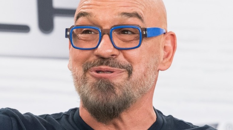 michael symon wearing glasses and speaking at microphone