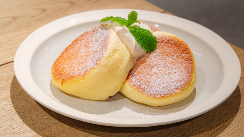 A plate of souffle pancakes with cream
