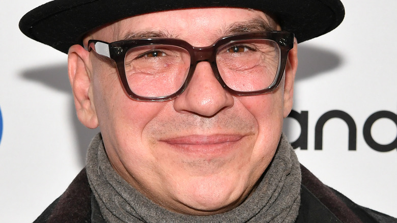 Michael Symon wearing black hat and glasses