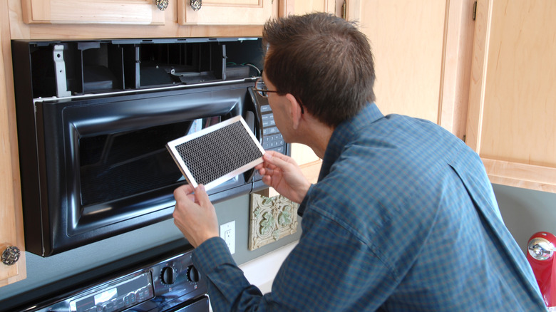 Person replacing microwave filter
