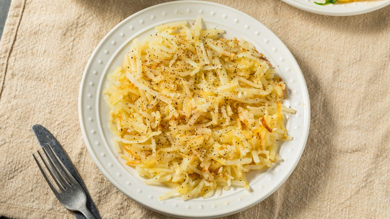Plate of shredded hash browns with black pepper