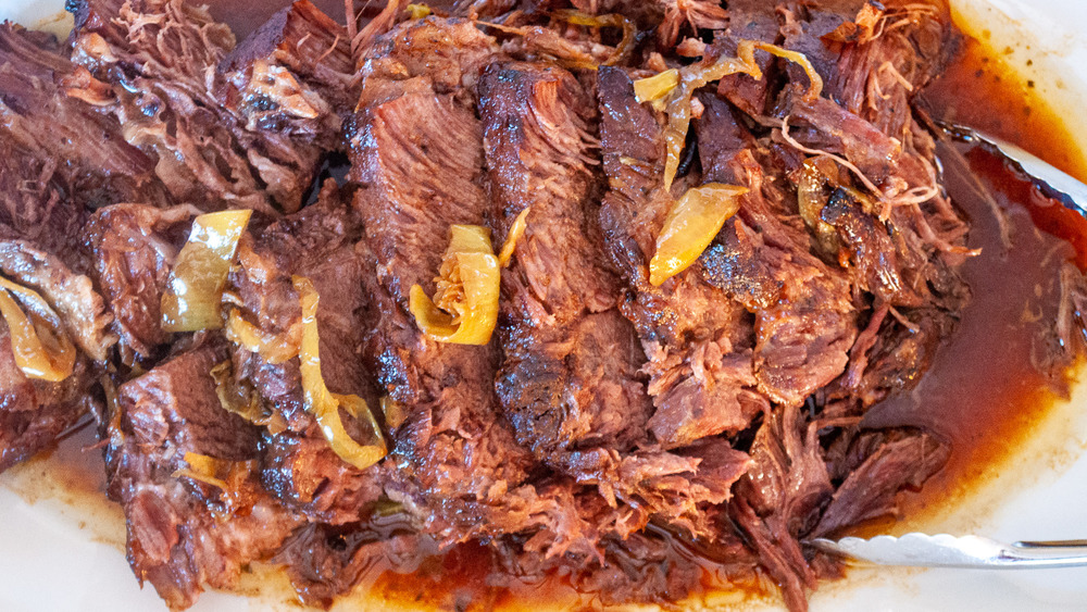 tongs reaching for Mississippi pot roast