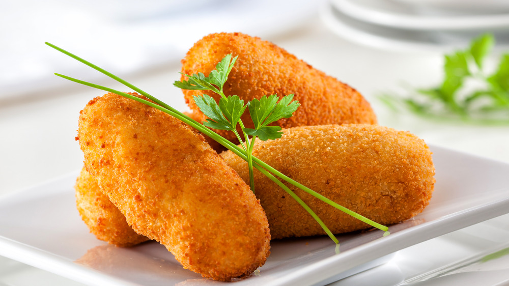 Four croquettes on a white plate