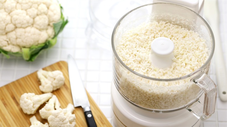 Cauliflower rice being made inside a food processor.