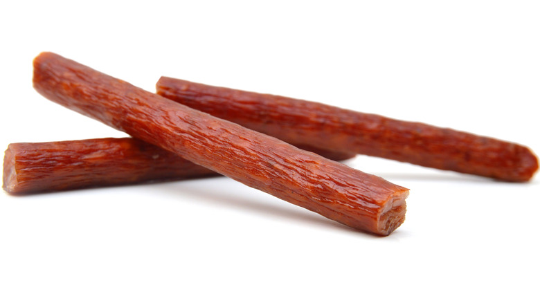 Three meat sticks on white background