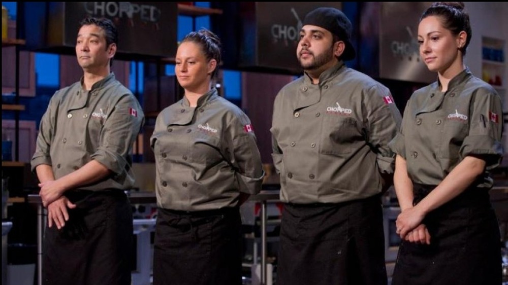 four Chopped contestants in aprons