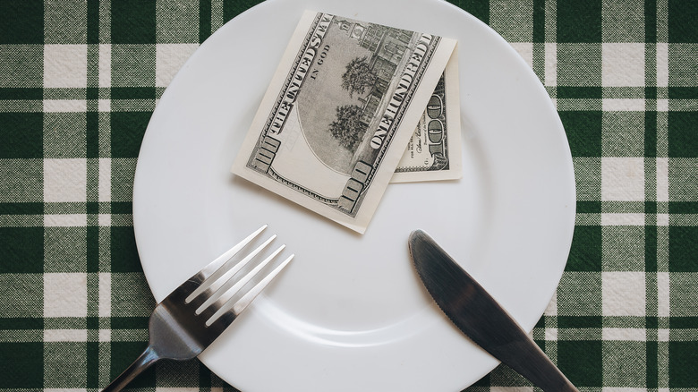 $100 bill on restaurant plate