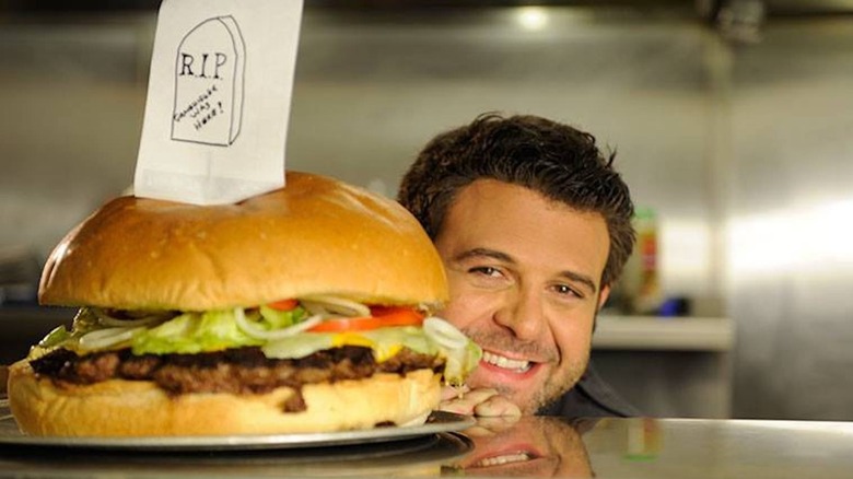 Adam Richman behind burger