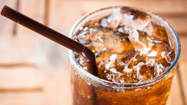 Glass of soda with ice and a straw 