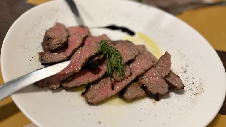 Veal steak with knives on plate 