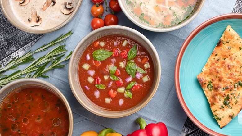 Different types of soup on a white wooden background