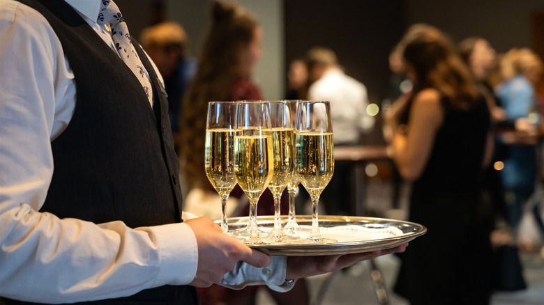 Waiter carrying champagne glasses