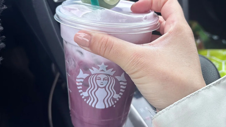 Hand holding a purple Starbucks Iced Lavender Latte