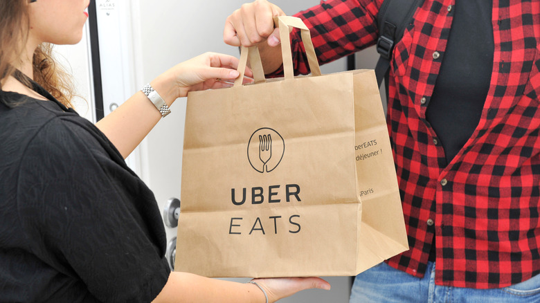 Person in red flannel receiving an Uber Eats bag