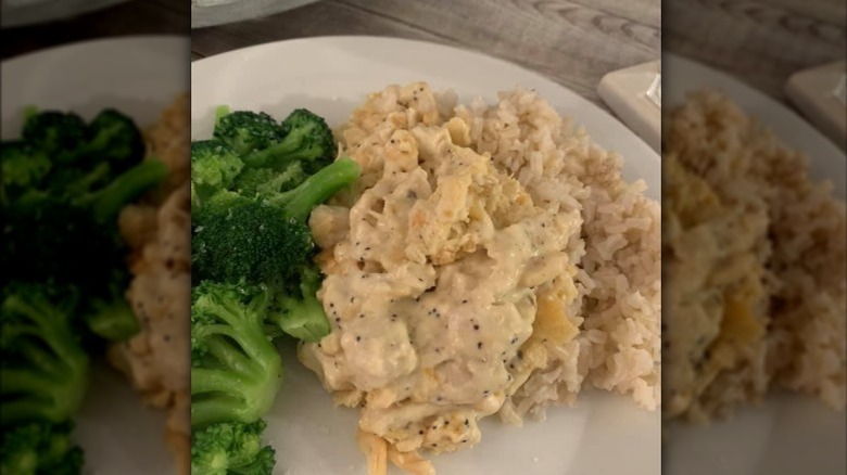 a helping of poppyseed chicken casserole with a side of broccoli on a white plate