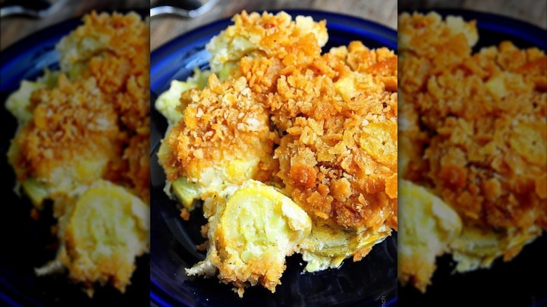 close up of a serving of squash casserole on a blue plate