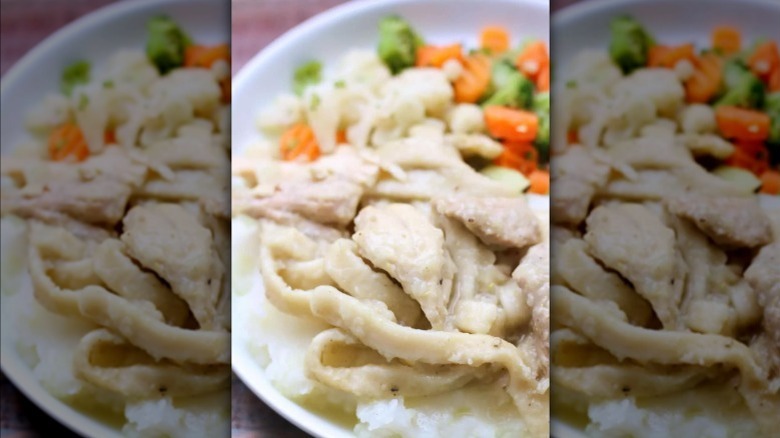 serving of Amish chicken and noodles with a side of veggies