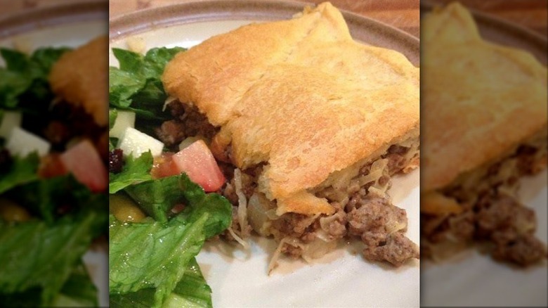 piece of bierock casserole with a side salad on a white plate