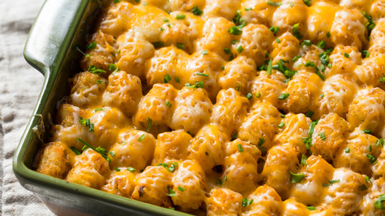 close up of a tater tot hotdish in a green baking dish