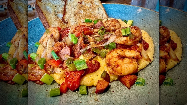 serving of shrimp and grits with bread on a ceramic plate