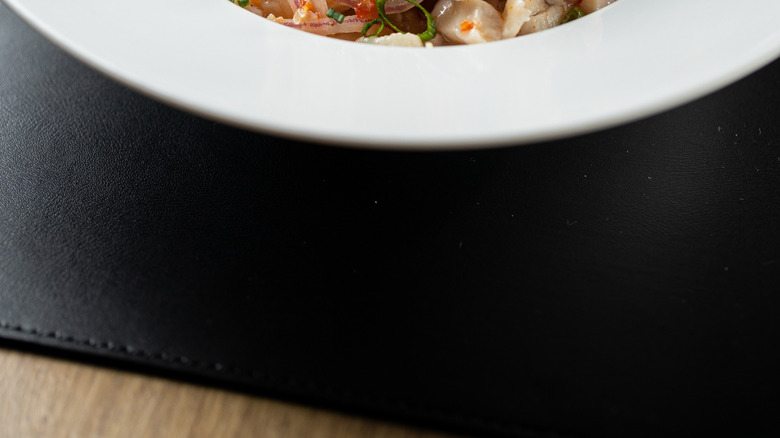 ceviche in a modern white bowl topped with seasonings