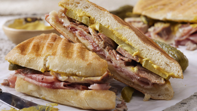 a sliced cuban sandwich up close on a paper wrapper