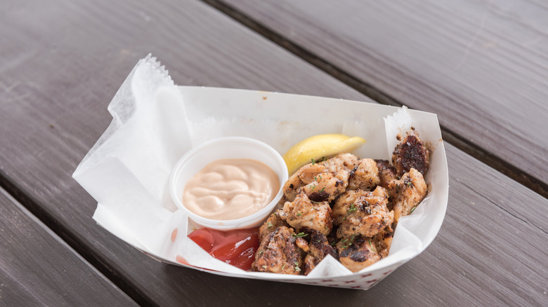gator bites in  abasket with remoulade, ketchup and lemon