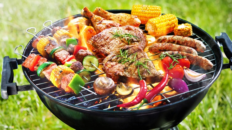 meat and veggies on a smoking grill 