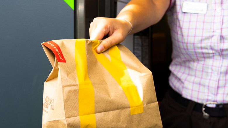 Employee handing bag at McDonald's drive-thru