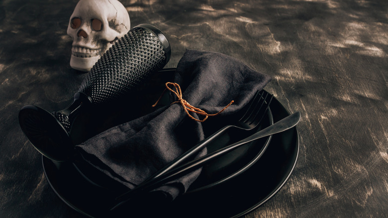 black table setting with skeleton