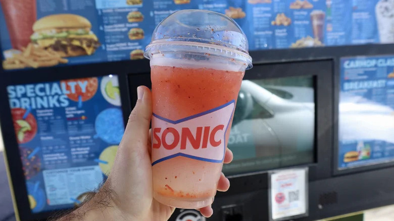 hand holding Sonic mangonada in drive-thru