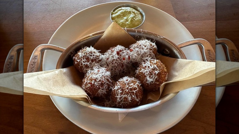 Meatballs from North Italia with shredded cheese in a small serving dish with handles