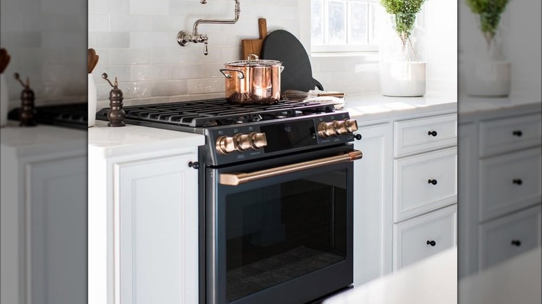 A white kitchen with a black Cafe stove