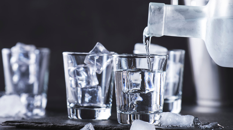 Vodka being poured into glass with ice