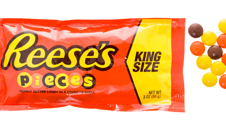 Package of Reese's Pieces with a few on the side