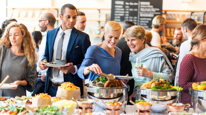 Line of people serving themselves at a buffet