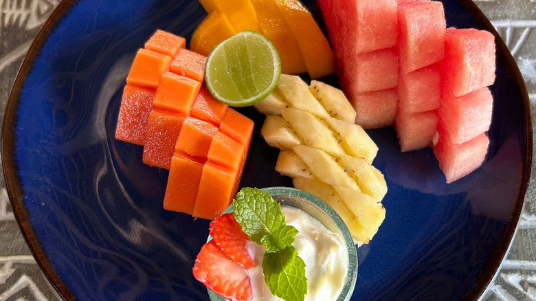 Plate of melon with bowl of fruit dip on the side