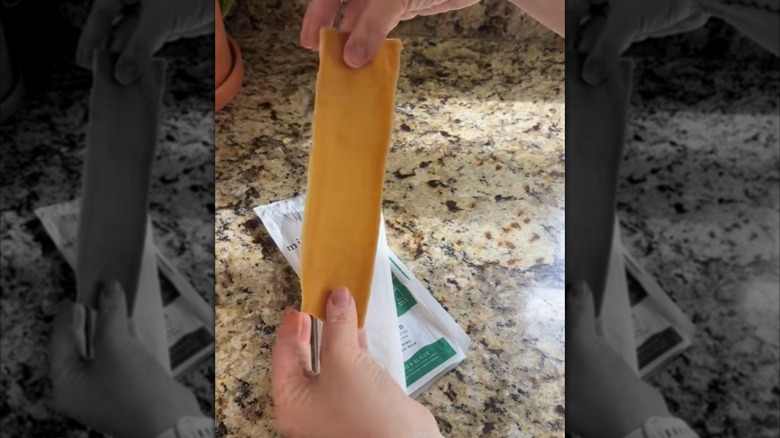 A lady's hands holding up a Milkadamia oat milk slice