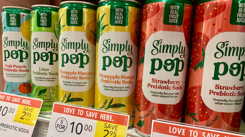 Simply Pop Prebiotic sodas in pineapple mango, strawberry, lime, and fruit punch flavors displayed on a shelf