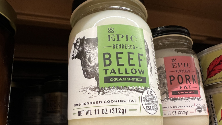 A bottle of grass-fed Epic Rendered Beef Tallow and another bottle of Pork Fat on a shelf